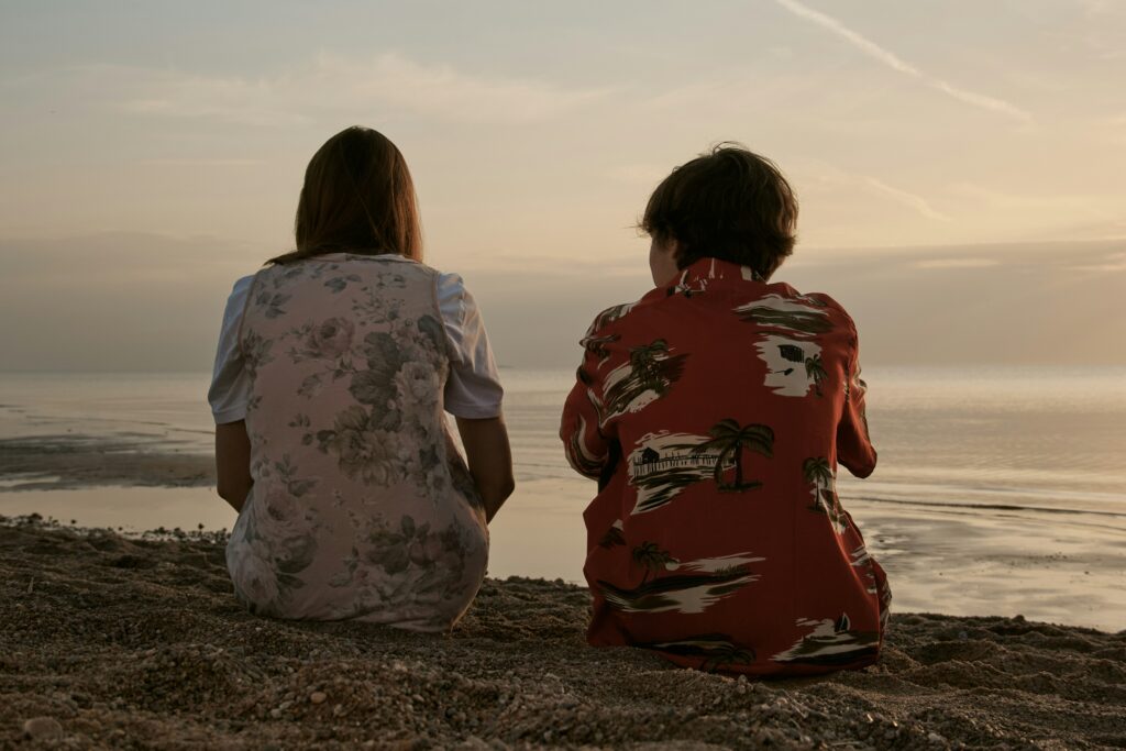 Two young people sitting looking out onto a horizon - this image is used to share online course "Understanding and responding to disclosures of child sexual abuse from children and young people".