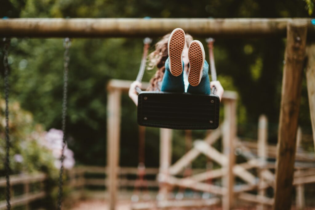 Young person on a swing set. This image is for blog titled 'How practitioners can fight child sexual exploitation', which was created to mark World Day of Fight against Sexual Exploitation
